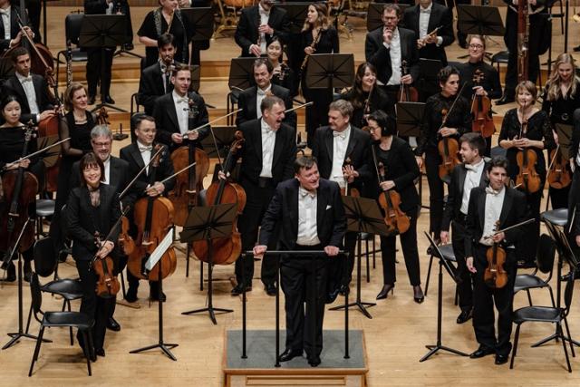 한국인 악장 이지윤(앞줄 왼쪽)이 포함된 독일 오케스트라 베를린 슈타츠카펠레와 지휘자 크리스티안 틸레만이 28일 롯데콘서트홀에서 연주를 마치고 객석에 감사 인사를 하고 있다. ⓒmidaby