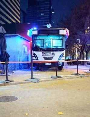 지난 11월 28일 오후 베이징 차오양구 량마허와 인접한 도로에 경찰 버스가 대기하고 있다. 이곳에선 전날 밤 대규모 시위가 벌어졌다. 사진=정지우 기자