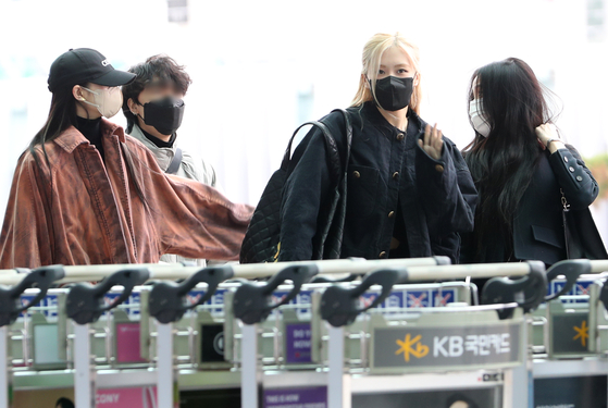 Members of girl group Blackpink arrive at Incheon International Airport in Seoul on Tuesday to leave for London for the European leg of the group's world tour. From right are members Jisoo and Rose. Lisa is at the far left. [NEWS1]