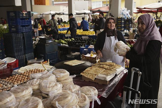 [앙카라=AP/뉴시스] 지난 20일(현지시간) 튀르키예 앙카라의 한 시장에서 여성 손님 한 명이 전통 빵을 사고 있다. 튀르키예 중앙은행은 24일 85%를 웃도는 물가상승률에도 기준금리를 4개월 연속 낮춰 9%로 1.5%P 인하했다. 2022.11.25