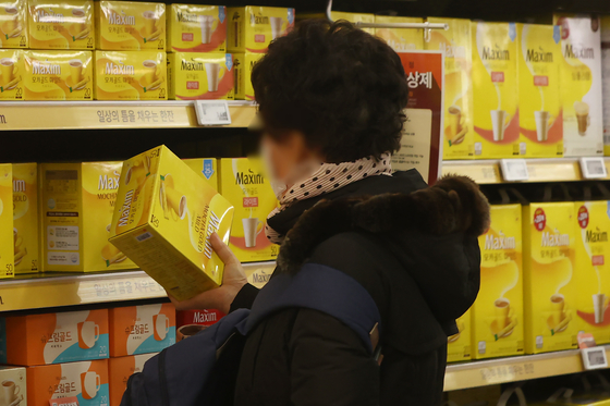 Dong Suh Foods Corporation will raise the prices of its coffee mix products, such as Maxim and Kanu, by 9.8 percent on average starting Dec. 15. The company last raised prices of the products in January. Above, a consumer grabs a box of Maxim coffee mix at a discount mart in Seoul on Thursday. [YONHAP]