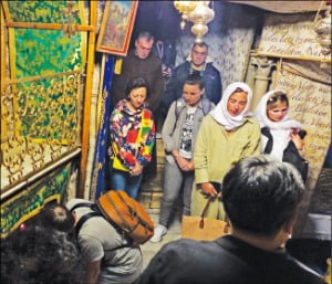 베들레헴 예수탄생교회 지하동굴에 표시된 예수 탄생 지점 앞에서 기도하는 순례객들.  베들레헴=구은서  기자