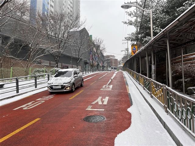 서울 성북구 정릉동 정수초등학교 앞 도로 아래로 열선이 깔린 부분에 눈이 쌓이지 않은 모습. 성북구 제공
