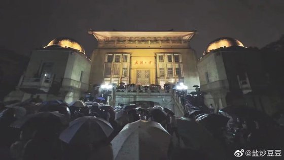 4일 밤 중국 후베이성 우한대학 본부 건물 앞에서 재학생 수백명이 우산을 쓴 채 구호를 외치며 귀향 허가를 요구하고 있다. 웨이보 캡쳐
