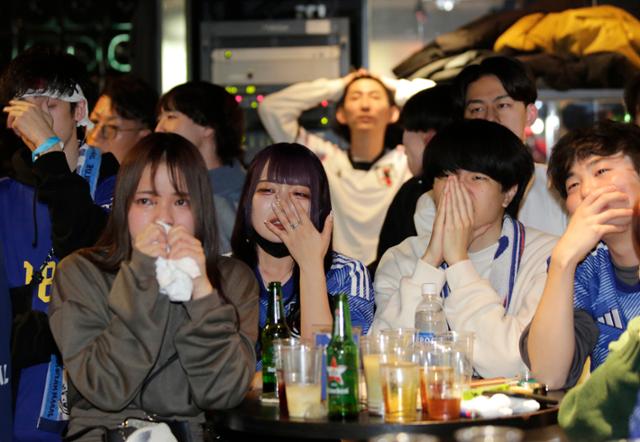 6일(한국시간) 새벽 2022 카타르 월드컵 16강전에서 일본 대표팀이 승부차기 끝에 크로아티아에 패해 8강 진출이 또다시 좌절되자 도쿄의 한 주점에서 TV를 보며 단체 응원을 하던 서포터들이 울먹이고 있다. 도쿄=EPA 연합뉴스