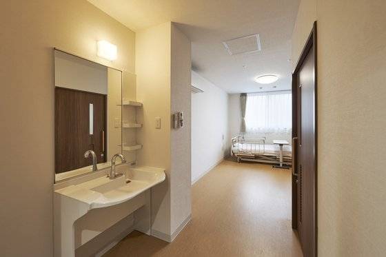 이신칸 내부 모습. 1인 1실 구조로 이사오듯 평소 쓰던 물건을 이곳에 가져와 쓸 수 있다. 방에는 세면대와 개인 화장실이 딸려있다. 병원에서 쓰는 환자용 침대와 작은 탁자가 구비돼 있다. 사진 앰비스