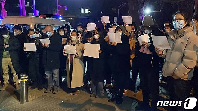 지난 11월 27일(현지시간) 중국 베이징에서 정부의 고강도 제로 코로나19 봉쇄 정책에 항의하는 시위가 발생한 가운데, 참가자들이 백지를 들며 항의하고 있다./사진=뉴스1