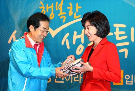 2011년 9월 28일 홍준표 당시 한나라당 대표가 나경원 의원에게 열심히 뛰라는 의미에서 운동화와 일찍 일어나 열심히 받아적으러라는 의미로 자명종과 수첩을 선물하고 있다. 중앙포토