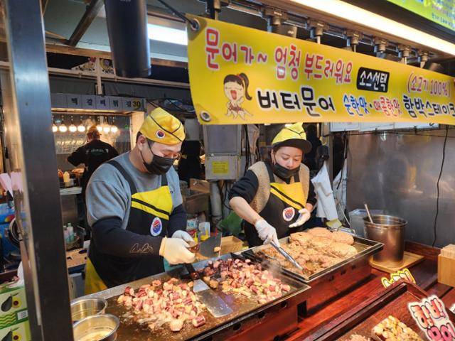 17일 제주시 이도1동 동문시장 야시장에서 4년째 영업 중인 김민서(오른쪽)씨와 박장호씨 부부가 버터문어구이를 조리하고 있다.