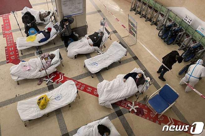 23일(현지시간) 코로나19 확산 속 중국 충칭의 병원 로비에 환자들이 침대에 누워 치료를 기다리고 있다. ⓒ AFP=뉴스1 ⓒ News1 우동명 기자