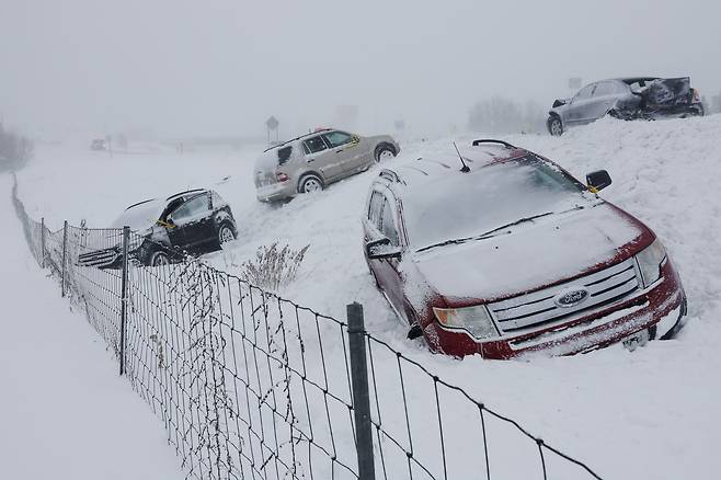 12월 23일(현지 시각) 겨울 폭풍 블리자드가 몰아친 미국 미시간주 바이런 센터 도로에 오도 가도 못한 차들이 눈속에 파묻혀 있다./The Grand Rapids Press via AP/연합뉴스