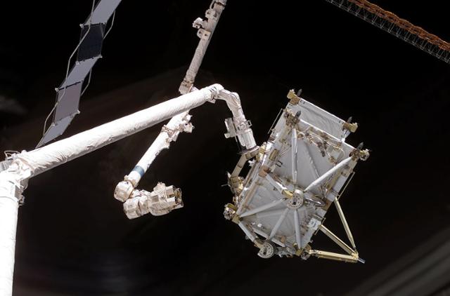 국제우주정거장의 캐나담2(위쪽)가 2006년 12월 우주왕복선 디스커버리호의 캐나담이 올린 수화물을 건네받고 있다. 나사 제공