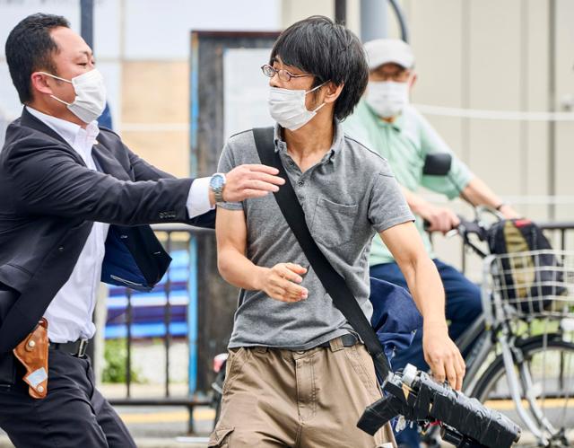 지난해 7월 8일 일본 나라시에서 아베 신조 전 총리 총격범 야마가미 데쓰야(가운데)가 경찰에 체포되고 있다. 나라=AP 연합뉴스