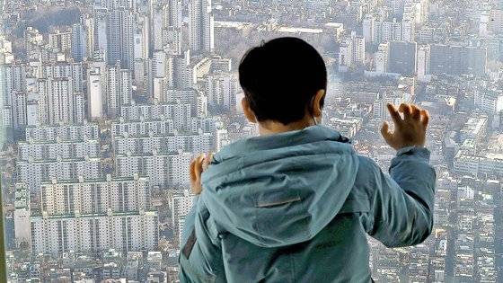 지난 1월2일 서울 송파구 롯데월드타워 서울스카이에서 한 어린이가 아파트 단지의 모습을 보고 있다. 뉴스1