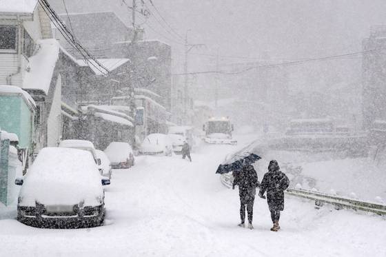 지난 24일 경북 울릉에 많은 눈이 내린 가운데 울릉 주민이 조심스럽게 길을 걷고 있다. 〈사진=울릉군 제공·연합뉴스〉