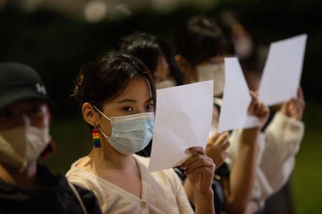 지난해 11월 홍콩 홍콩대에서 중국 본토 유학생들이 중국 우루무치 화재 희생자 추모집회에서 중국 정부의 '제로 코로나' 정책에 반대하는 의미로 백지를 들고 있다. [이미지출처=연합뉴스]