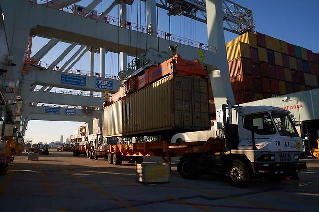 25일(현지시간) 미국 매사추세츠의 보스턴 항구에서 선적 컨테이너들이 트럭에 실리고 있다.  <사진출처-블룸버그>
