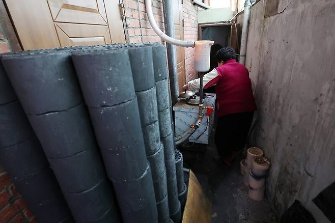 26일 오후 광주 동구 지산2동 한 주택에서 난방 취약계층 노인이 연탄불을 살펴보고 있다. 연합뉴스
