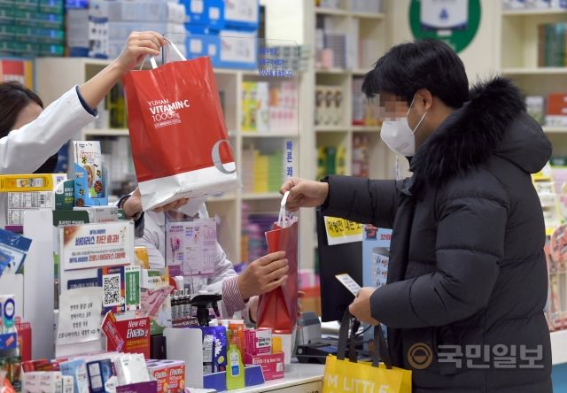 30일 서울 시내의 한 대형마트 약국에서 한 고객이 마스크를 쓴 채 물품을 구매하고 있다.
