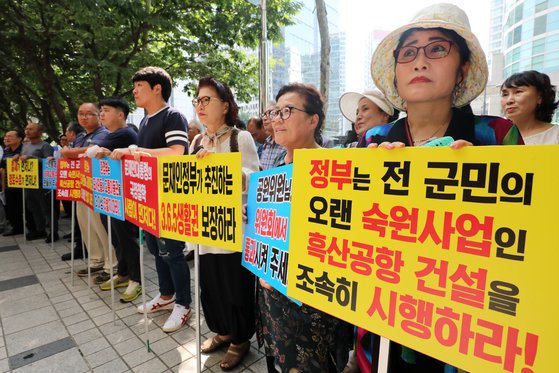 흑산공항 건설 조기 착공을 지지하는 주민들이 2018년 7월 서울 마포구 태영빌딩 앞에서 열린 흑산도 신공항 건설 조기 착공 결의대회에서 피켓을 들고 있다. 뉴스1