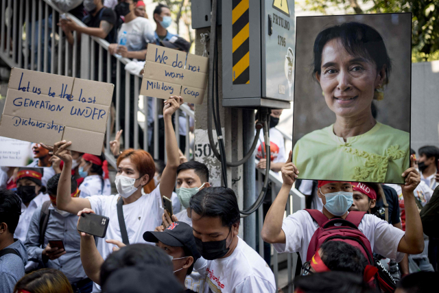 ▲미얀마 군부가 쿠데타를 일으켜 정권을 장악한 지 2년이 된 1일(현지시각) 태국 방콕 주재 미얀마 대사관 앞에서 시민들이 아웅산 수치 미얀마 국가고문 사진을 들고 민주화를 요구하는 시위를 벌이고 있다.  ⓒAFP=연합뉴스