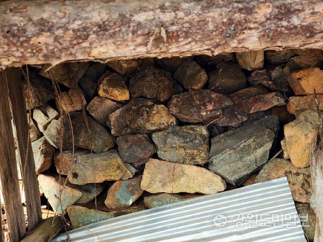 ▲ 동해시 이기동 백두대간 능선 아래 동점마을에서 발견된 쇠부리터에서 선철작업을 할 때 나온 부산물인 슬러그 덩어리, 철광석 등을 우물 벽으로 쓴 모습.