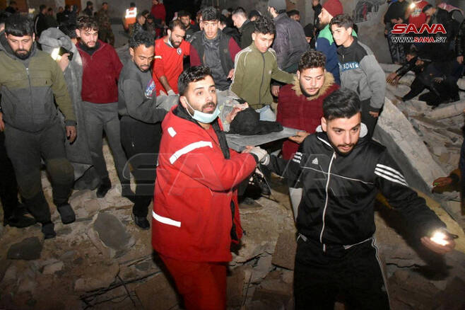 강진이 강타한 6일(현지시간) 시리아 하마에서 구조대원들이 무너진 건물 사이에서 부상자를 구조하고 있다. 로이터연합뉴스