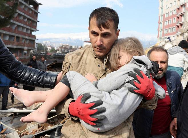 한 아이가 지진 피해 현장에서 구조되는 모습 (사진=로이터)