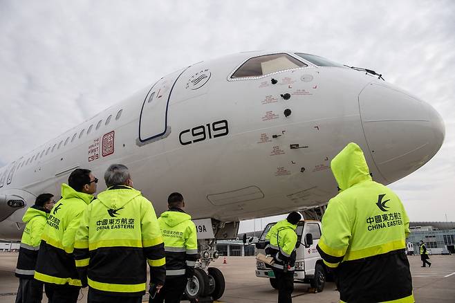 지난달 16일 중국동방항공 직원들이 중국 후베이성 ​​우한 톈허 국제공항에 착륙한 후 중국 최초의 국산 여객기인 C919를 점검하고 있다. /AFP연합뉴스
