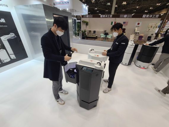 로보티즈 직원들이 일본 호텔&레스토랑 박람회 'HCJ 2023' 행사장에서 자율주행로봇 '집개미'를 시연하기 위해 준비하고 있다. 로보티즈 제공