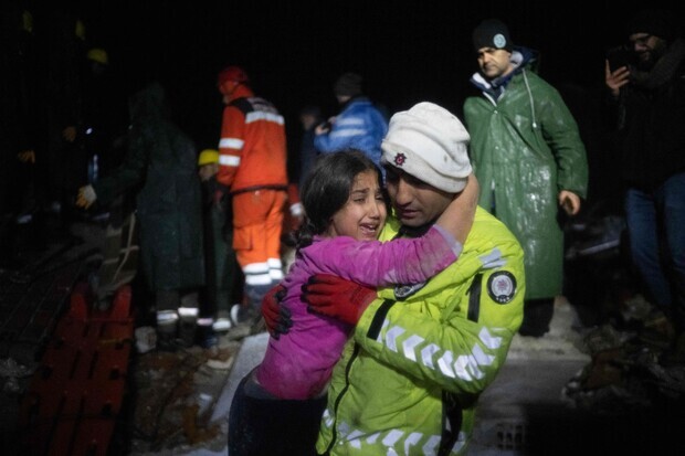 경찰이 6일 튀르키예 하타이에서 지진으로 무너진 건물 더미에서 딸을 구해내고, 놀란 아이를 안아서 달래고 있다. AFP 연합뉴스