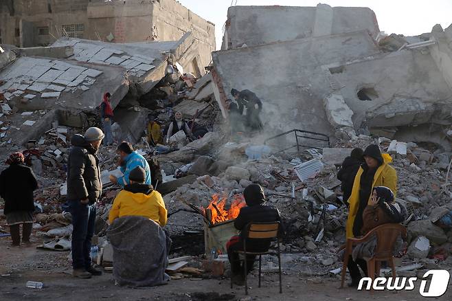 지진 발생 사흘째를 맞은 8일(현지시간) 튀르키예 카흐라만마라스에서 주민들이 무너진 건물 잔해 옆에서 구조 작업 중 잠시 쉬고 있다. ⓒ 로이터=뉴스1 ⓒ News1 최종일 기자