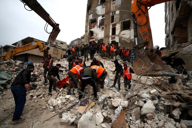 6일(현지시간) 시리아 하마에서 민방위대와 보안군이 지진으로 무너진 건물 잔해를 수색하고 있다. 이날 새벽 시리아 인근 튀르키예에서 발생한 지진으로 사망자 숫자가 늘어나고 있다. AP 뉴시스