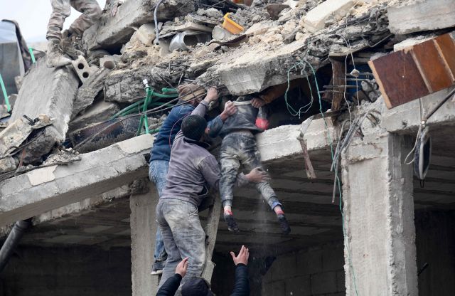 6일(현지시간) 시리아 알레포주 아프린시 잔다리스의 붕괴한 건물 잔해에서 시민들이 다친 여자아이를 구조하고 있다. AFP 연합뉴스