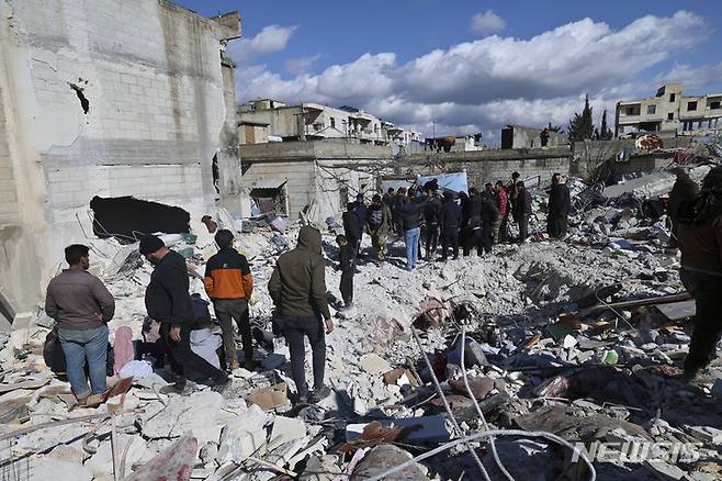 [진데리스=AP/뉴시스] 7일(현지시간) 잔해 속에서 신생아가 발견된 시리아 진데리스에서 주민들이 건물 잔해를 수색하고 있다. 튀르키예와 시리아를 강타한 지진으로 지금까지 사망자가 7800명을 넘은 것으로 나타났다. 2023.02.08.