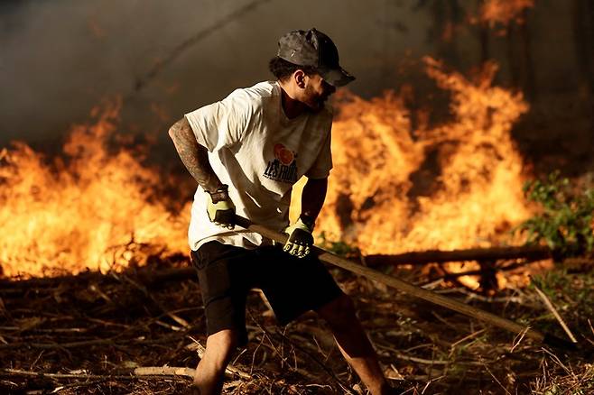 지난 7일 칠레 콘셉시온 인근 라파엘에서 한 주민이 산불을 진화하고 있다. 로이터 연합뉴스