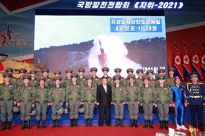 2021년 10월 국방발전전람회 '자위-2021'에 참석해 군을 독려하고 기념사진을 촬영한 김정은. 스크린에 나오는 KN-24가 '화성포-11나형'이라고 명명돼 있다. 뉴스1 제공