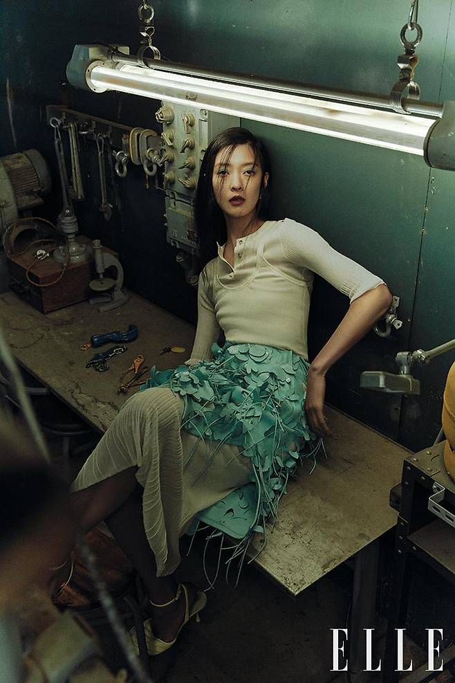 롱 슬리브 코튼 톱과 울 탱크톱, 입체적인 플라워 모티프의 스커트, 코튼 언더 스커트, 앵클 스트랩 펌프스, 이어링은 모두 Bottega Veneta.