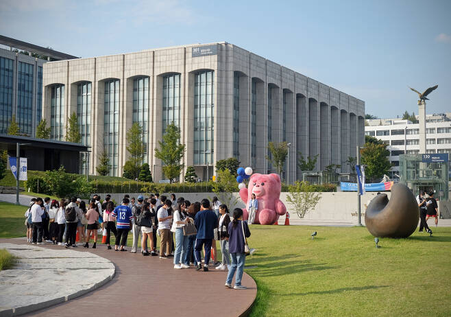 Students queue in front of Bellygom to take pictures at Yonsei University's Sinchon campus on Thursday. [ALLAND DHARMAWAN]