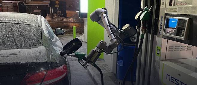 주유 로봇이 자동차에 연료를 넣고 있다. 사람의 팔처럼 생긴 주유 로봇은 주유구 개방과 연료 주입, 결제까지 모두 스스로 해낸다. 오토퓨얼 제공