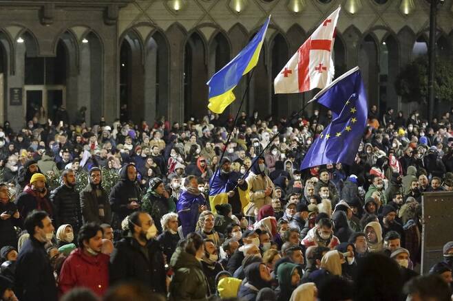 8일(현지시간) 조지아 트빌리시 국회의사당 앞에서 ‘외국 대리인법’에 반대하는 시위대가 우크라이나, 조지아, 유럽연합(EU) 깃발을 흔들고 있다. AP연합뉴스