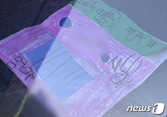 40대 가장이 아내와 자녀 3명을 흉기로 살해한 후 극단적 선택을 한 18일 인천시 미추홀구 한 주택 앞에 주차된 차량에 '엄마 사랑해' 가 적힌 아이가 그린 것으로 보이는 그림이 놓여 있다. 2023.3.18/뉴스1