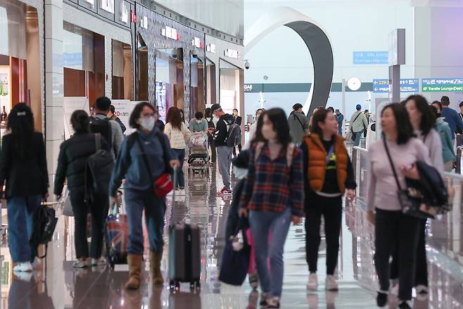 Travelers walk through the duty-free zone of Incheon Airport Terminal 2 on March 12. (Yonhap)