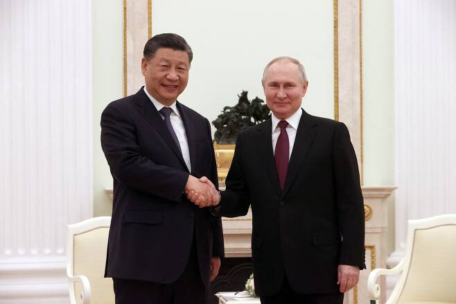 사진핑(왼쪽) 중국 국가주석과 블라디미르 푸틴 러시아 대통령이 20일 러시아 모스크바 크렘린궁에서 비공식 회동을 앞두고 악수를 나누고 있다. 시진핑의 이번 러시아 방문은 이달 초 국가주석 3연임을 확정한 이후 첫 해외 방문이다./로이터 연합뉴스