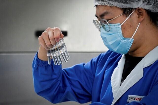 지난 2020년 9월 중국 베이징의 한 제약사 직원이 백신을 확인하고 있다. 베이징/AFP 연합뉴스