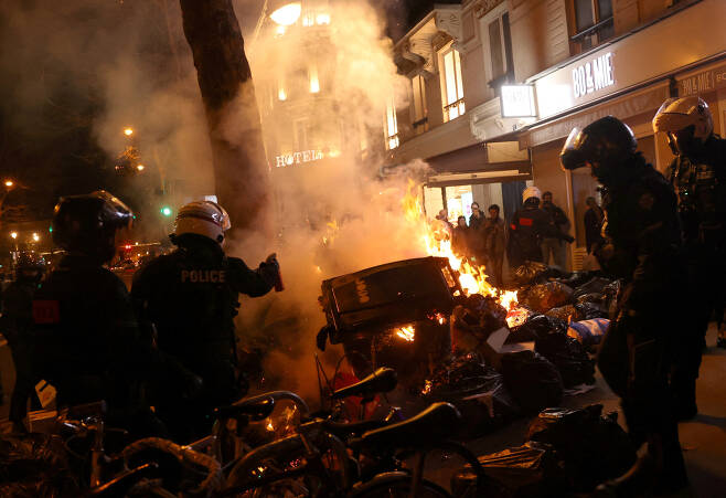 지난 23일(현지시간) 프랑스 경찰이 파리 시내에서 정부의 연금 개혁에 반대하는 시위 도중 화재가 발생하자 이를 진압하고 있다. 로이터 연합뉴스