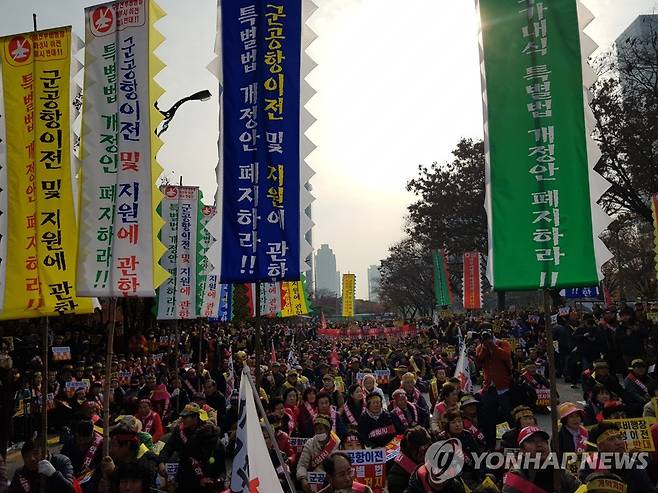 "수원 군 공항, 화성 이전 반대" (서울=연합뉴스) 이동환 기자 = 수원 군 공항 이전을 반대하는 화성시 주민들이 2018년 11월 19일 서울 여의도 산업은행 앞에서 결의대회를 열고 군 공항 이전 계획 철회를 촉구했다. 2018.11.19