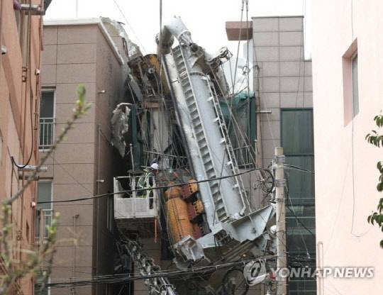 지난 29일 울산시 남구 한 아파트 공사 현장에서 천공 중장비인 항타기가 넘어져 인근 원룸 건물을 덮친 가운데 30일 오후 항타기를 해체하는 작업이 이뤄지고 있다. 사진 연합뉴스