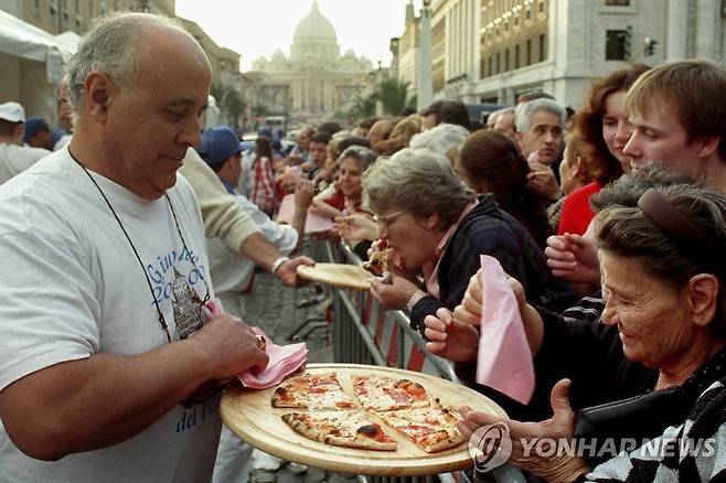 이탈리아 로마 성베드로광장 인근에서 순례자들이 무료로 제공된 피자를 먹는 모습. [AP 연합뉴스 자료사진. 재판매 및 DB 금지]