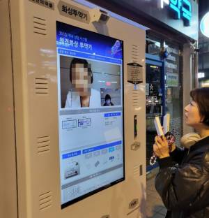 화상투약기 시범사업이 시작된 30일 서울 동작구 소재 한 약국 앞에 설치된 화상투약기에서 약사가 화면을 통해 안경진 서울경제신문 기자에게 복약 지도를 하고 있다. 안경진 기자